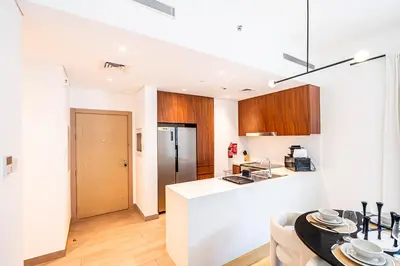 a kitchen with a white counter top and a table at Escape24 Luxury 2BR Sea View with Beach Access in La Mer in Dubai
