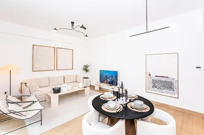 a white living room with a table and chairs at Escape24 Luxury 2BR Sea View with Beach Access in La Mer in Dubai