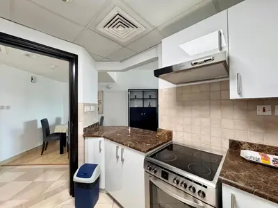 a kitchen with white cabinets and a stove top oven at 2 Bed Apartment in La Riviera Tower, Dubai Marina near Metro and Mall, 12-min walk to JBR Beach! in Dubai