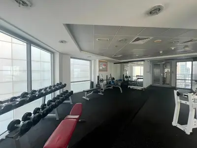 a gym with chairs and machines in a building at 2 Bed Apartment in La Riviera Tower, Dubai Marina near Metro and Mall, 12-min walk to JBR Beach! in Dubai