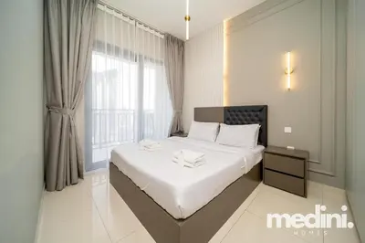 a bedroom with a bed with white sheets and a window at New Listing - Sauna - Gym Pool - Business Bay in Dubai