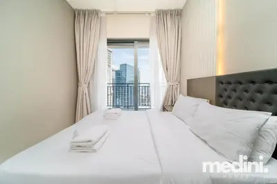 a bedroom with a large white bed with a window at New Listing - Sauna - Gym Pool - Business Bay in Dubai