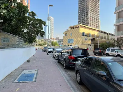 a bunch of cars parked on the side of a street at Jumeirah Village Circle JVC One bedroom Luxurious Apartment in Dubai