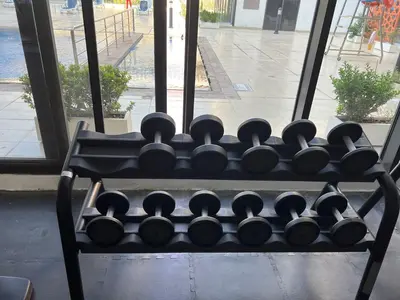 a rack of dumbbells sitting in front of a window at Jumeirah Village Circle JVC One bedroom Luxurious Apartment in Dubai