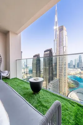 a room with a large window with green grass and a table at Luxurious 4BR, Burj Khalifa & full fountain view, Downtown Dubai in Dubai