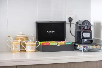 a kitchen counter with a coffeemaker and books and cups at Luxurious 4BR, Burj Khalifa & full fountain view, Downtown Dubai in Dubai