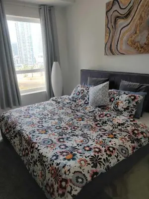 a bed with a floral comforter and a window at AHLAN Dubai Marina JBR in Dubai