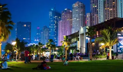 a city skyline at night with people in a park at AHLAN Dubai Marina JBR in Dubai