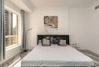 a bed in a white room with a large window at AHLAN Dubai Marina JBR in Dubai