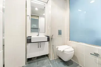 a white bathroom with a toilet and a sink at Silkhaus Sea View Studio in Palm Jumeirah in Dubai