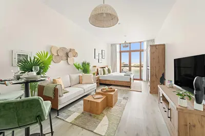 a living room with a couch and a tv at Silkhaus Beach Access Studio in Palm Views East in Dubai