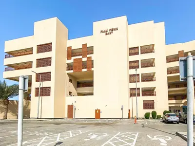 a building with a parking lot in front of it at Silkhaus Beach Access Studio in Palm Views East in Dubai