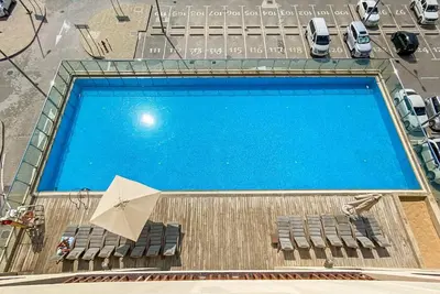 an overhead view of a swimming pool with chairs and an umbrella at Silkhaus Offshore Studio in Palm Views East Tower in Dubai