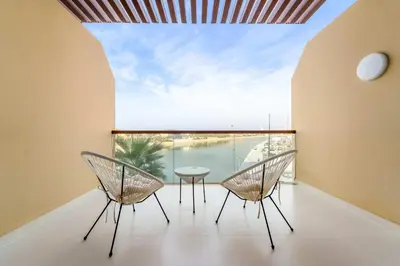 a room with two chairs and a table on a balcony at Silkhaus Offshore Studio in Palm Views East Tower in Dubai