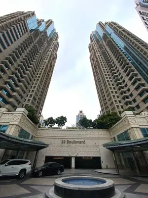 two large buildings with cars parked in a parking lot at Silkhaus 1BR Downtown Heart in Emaar Tower in Dubai