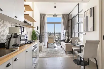 a kitchen and living room with a couch and a table at Modern 1BR at Collective Tower 1 Near Hills Mall in Dubai
