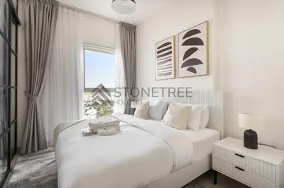 a white bedroom with a large bed and a window at Modern 1BR at Collective Tower 1 Near Hills Mall in Dubai