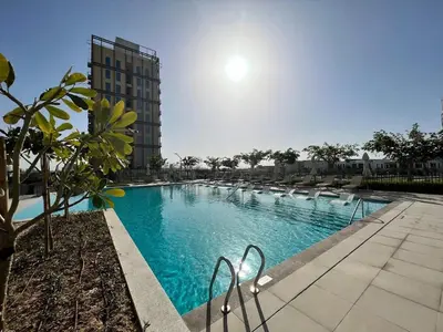 a large swimming pool in front of a building at Modern 1BR at Collective Tower 1 Near Hills Mall in Dubai