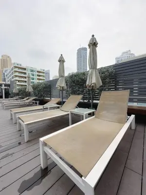 a row of lounge chairs and umbrellas on a roof at Chic Marina Vibes 1BR Pad with Epic Views in Dubai