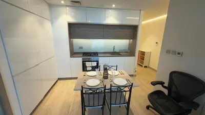 a kitchen with a table and chairs in a room at Chic Marina Vibes 1BR Pad with Epic Views in Dubai