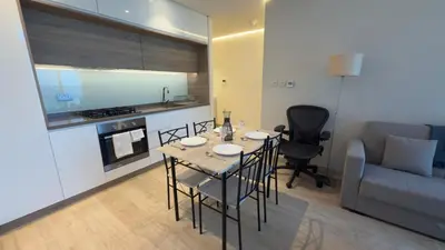 a kitchen with a table and chairs in a room at Chic Marina Vibes 1BR Pad with Epic Views in Dubai