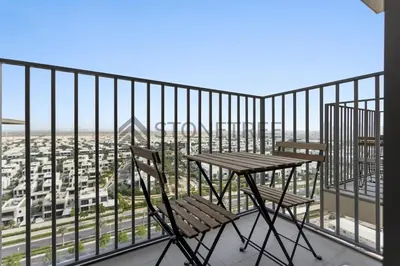a table and chair on a balcony with a view at Cozy 1BR at Collective Tower 1 Near Hills Mall in Dubai