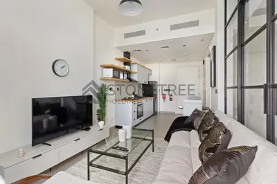 a living room with a large white couch and a tv at Cozy 1BR at Collective Tower 1 Near Hills Mall in Dubai