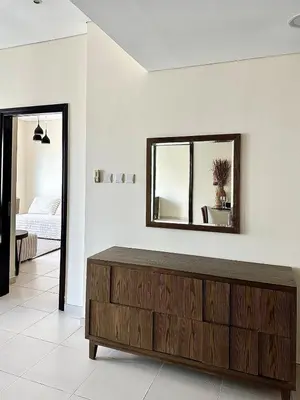a living room with a wooden dresser and a mirror at Dubai Marina, 2 Bedrooms, apartment, sea view, JBR in Dubai