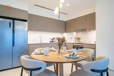 a kitchen with a wooden table and chairs at Cozy 2-Bed Home with Burj Khalifa Views 204GR-2 in Dubai