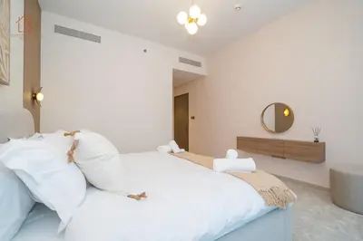 a bedroom with a white bed and a mirror at Cozy 2-Bed Home with Burj Khalifa Views 204GR-2 in Dubai