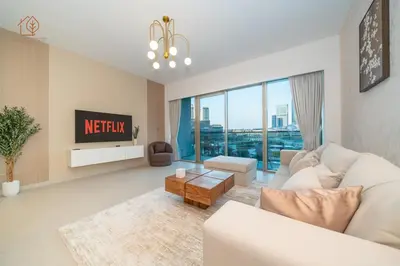 a living room with a white couch and a tv at Cozy 2-Bed Home with Burj Khalifa Views 204GR-2 in Dubai