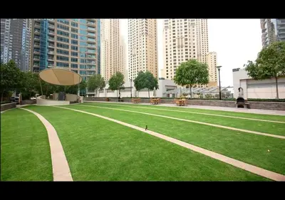 a large grassy field in a city with tall buildings at Blakely 2BR Lakeview Retreat - Open Balcony and Marina Views in Dubai