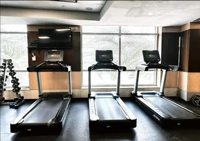 a gym with two tread machines and a window at Blakely 2BR Lakeview Retreat - Open Balcony and Marina Views in Dubai