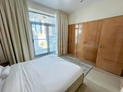 a bedroom with a bed and a large window at Blakely 2BR Lakeview Retreat - Open Balcony and Marina Views in Dubai