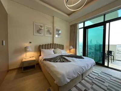 a bedroom with a large bed and a large window at Sunset Haven Chic Creek Studio in Dubai