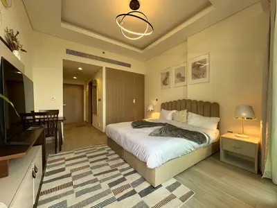 a bedroom with a large bed and a living room at Sunset Haven Chic Creek Studio in Dubai