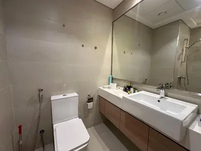 a bathroom with a sink and a toilet and a mirror at Sunset Haven Chic Creek Studio in Dubai