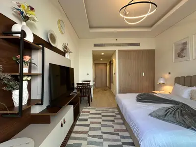 a hotel room with a bed and a television at Sunset Haven Chic Creek Studio in Dubai