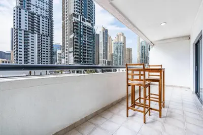 a chair on a balcony with a view of a city at Elegant Home in the Heart of Marina in Dubai