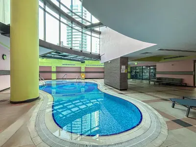 a large swimming pool in a large building at Elegant Home in the Heart of Marina in Dubai
