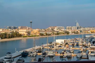 a bunch of boats docked in a marina with a city at Deluxe Waterfront Unit in Heart Of Dubai Palm Jumeirah in Dubai