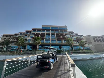 a golf cart parked on a boardwalk in front of a building at Deluxe Waterfront Unit in Heart Of Dubai Palm Jumeirah in Dubai