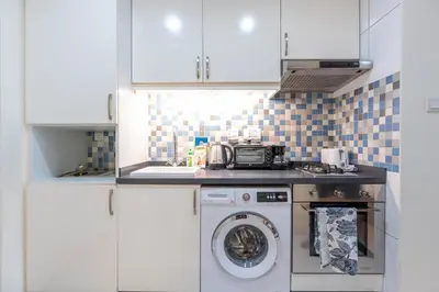 a kitchen with a washer and a washing machine at Deluxe Waterfront Unit in Heart Of Dubai Palm Jumeirah in Dubai