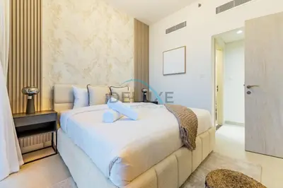 a bedroom with a large white bed with blue pillows at Charming 1BR in Dania 3, IMPZ by Deluxe Holiday Homes in Dubai