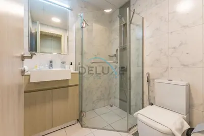 a bathroom with a shower and a toilet and a sink at Charming 1BR in Dania 3, IMPZ by Deluxe Holiday Homes in Dubai