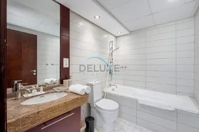 a bathroom with a toilet and a tub and a sink at Tranquil 1BR in Burj Views Tower B, Downtown by Deluxe Holiday Homes in Dubai