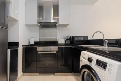 a kitchen with a sink and a stove and a dishwasher at Sea View, Easy Access, Close to All Amenities in Dubai