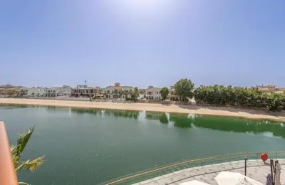 a large body of water with houses in the background at The Pretty Pad on The Palm! in Dubai