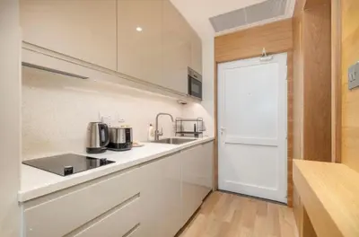 a kitchen with white cabinets and a counter top at The Pretty Pad on The Palm! in Dubai