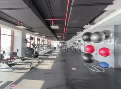 a gym with cardio machines and balloons on the wall at The Pretty Pad on The Palm! in Dubai